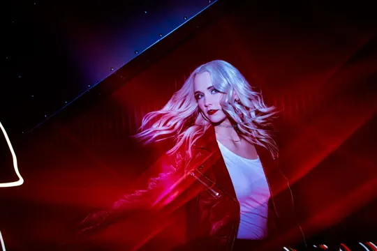 MADY with flowing hair in red-lit environment, dynamic motion blur.