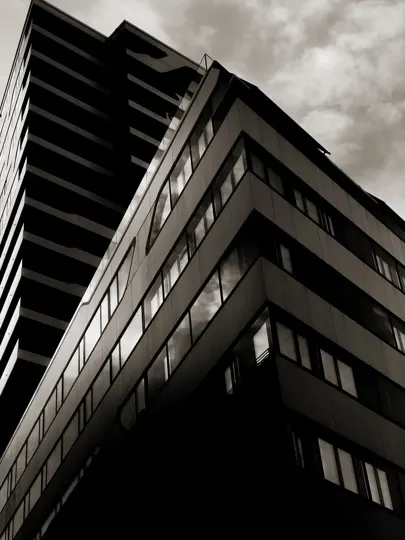 Angular modernist buildings rise under a moody, overcast sky.