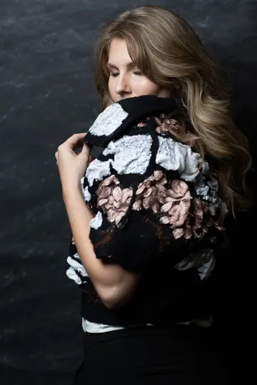 H.LANE Design textured floral garment, dark backdrop, soft chiaroscuro lighting.