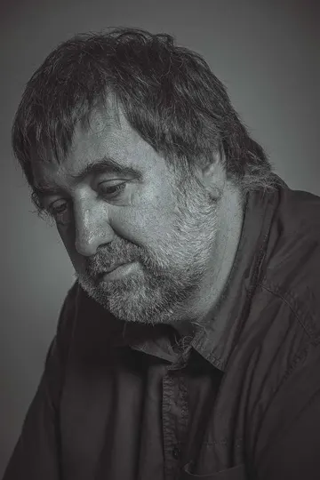 A contemplative man with a beard, captured in soft, diffused studio lighting.